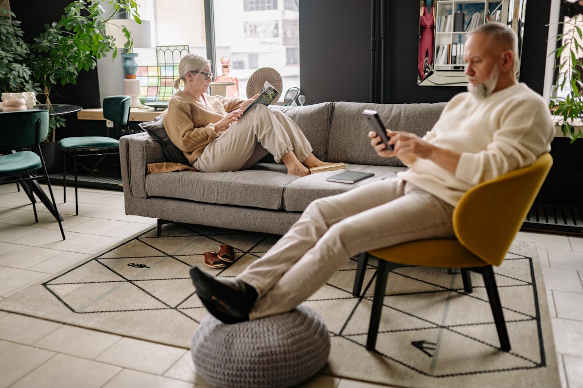 An elderly couple reading together